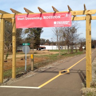 An arbor marks the southern terminus of the Tanglefoot Trail. The attached sign recognizes the CIRD project.